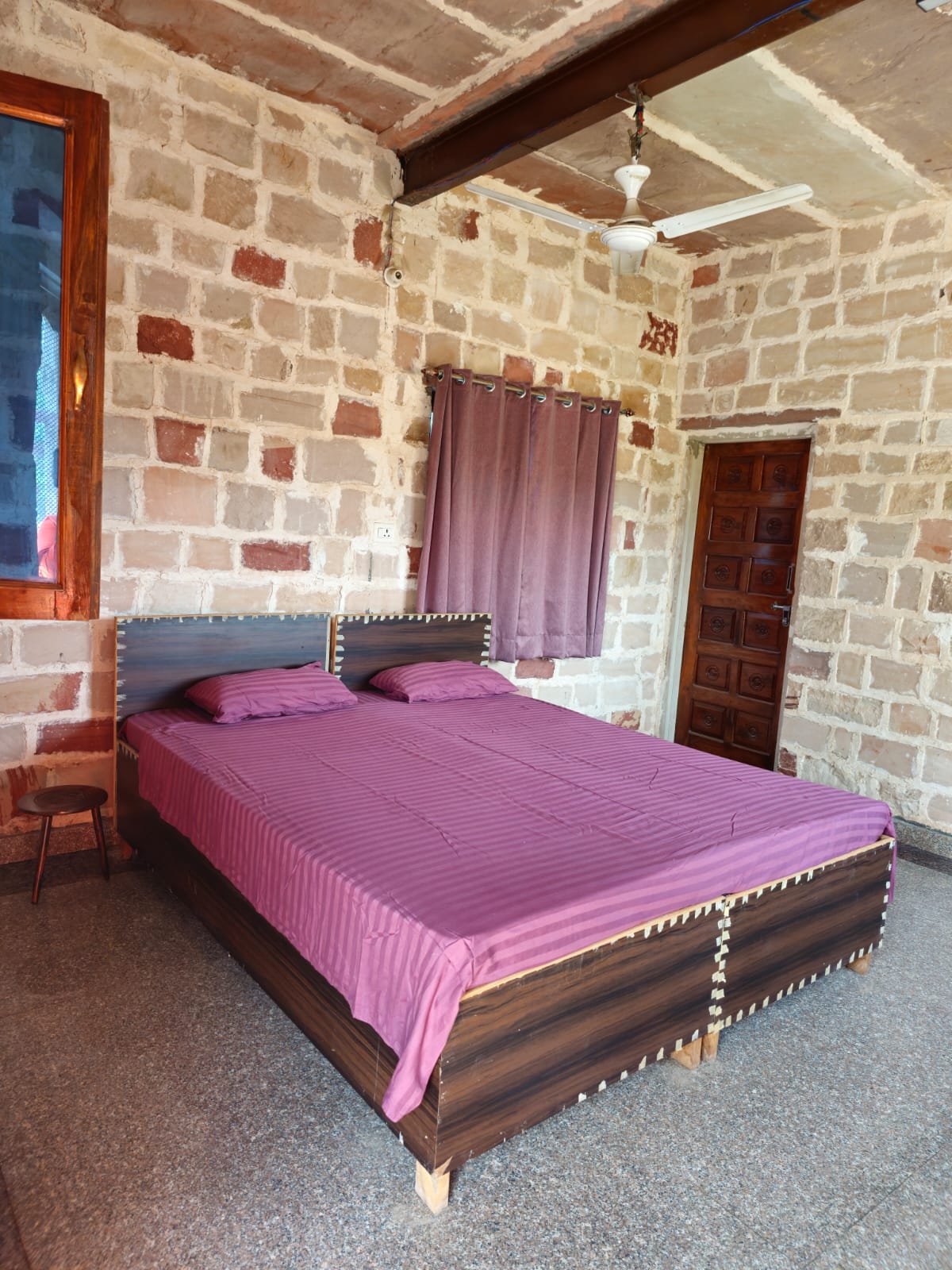 A simple private bedroom with terracotta walls and white linens