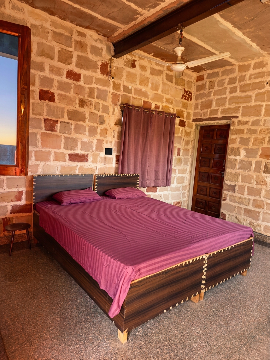 A simple private bedroom with terracotta walls and white linens